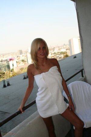 Blue eyed blonde Hanna unveils her great tits and smooth pussy on the balcony on picsofsex.com