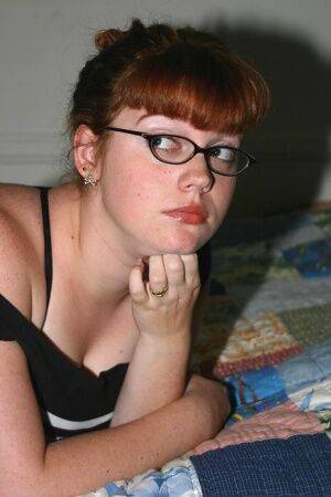 Chubby nerd with red hair takes off her glasses after uncupping big naturals on picsofsex.com