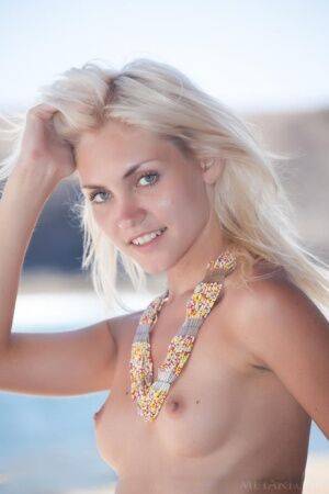 Young blonde Cristina A models totally nude at a beac house getaway on picsofsex.com