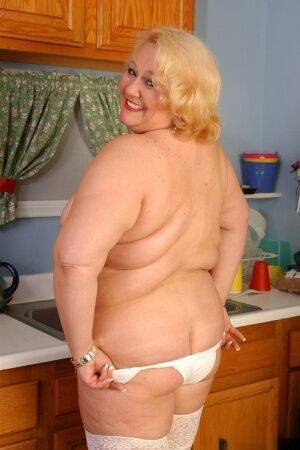 Older fat lady Britany models white stockings and underwear in the kitchen on picsofsex.com