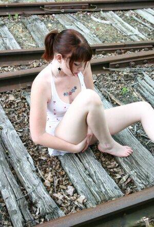 Redheaded girl Barbie A models a summer dress in bare feet on railway tracks on picsofsex.com