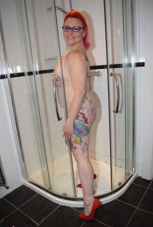 Tattooed redhead Mollie Foxxx models completely naked in a bathroom on picsofsex.com