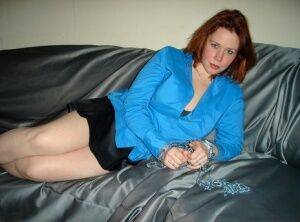 Redheaded girl gets naked on a sofa while sporting a collar and chains on picsofsex.com