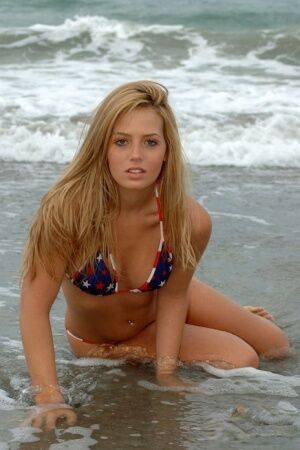 Blonde girl Shannon models in the surf wearing a bikini and a smile on picsofsex.com