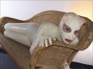 Bald female models rubber attire during a solo engagement on picsofsex.com