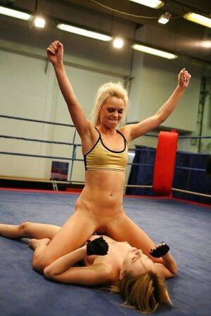 Pretty lesbians gasping and stripping each other in the wrestling ring on picsofsex.com