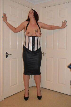 Amateur woman Sara Banks hikes up her leather skirt well in her bedroom on picsofsex.com