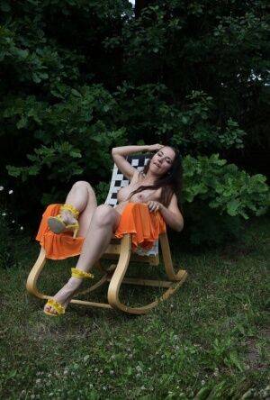 Barely legal brunette Nicole V gets naked on a backyard rocking chair on picsofsex.com