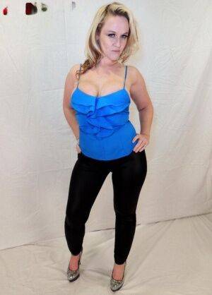 Blonde amateur Dee Siren displays her cleavage while wearing black leggings on picsofsex.com