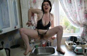 Amateur woman Juicey Janey squats over the kitchen sink for a piss on picsofsex.com