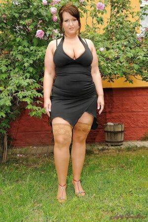 Seductive mature plumper in stockings taking off her dress outdoor on picsofsex.com