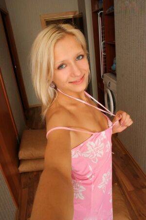 Natural blonde Nastya takes self shots while getting naked in a hallway on picsofsex.com