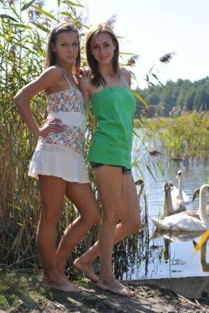 Young lesbians Nastya and Ashly get undressed atop a blanket on a dock on picsofsex.com