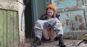 Cute girl pulls down jeans for an urgent piss on the steps of an old building on picsofsex.com