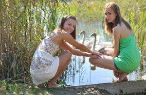 Young lesbians Nastya & Ashly get naked on a dock in the reeds on picsofsex.com