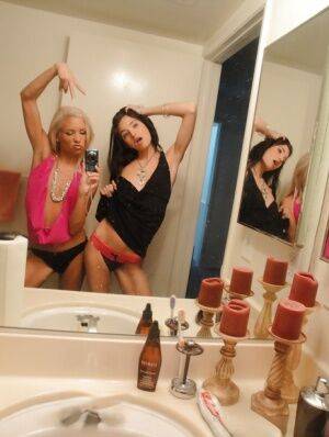 Skinny girls Kacey and Zoey showing off teenie tits while taking mirror selfie on picsofsex.com