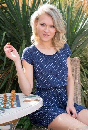 Young blonde Kira Angel gets totally naked atop an outdoor chessboard on picsofsex.com