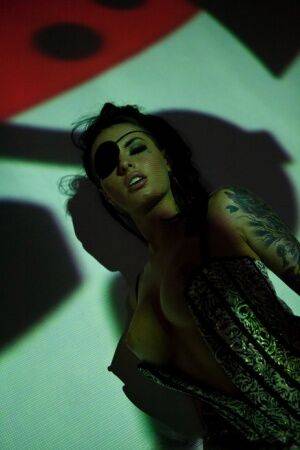 Solo girl Christy Mack wears an eye patch and lingerie while posing in shadows on picsofsex.com