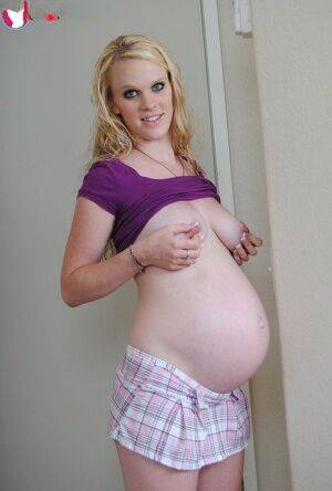 Blonde girl Hydii May puts her pregnant belly on display in knee socks on picsofsex.com