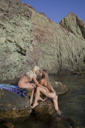 Against the wet and rugged landscape of a river, Nika and Milena makes a on picsofsex.com