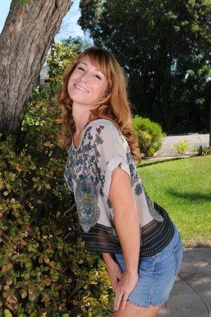 Redhead MILF Sophia K removes jean shorts as she disrobes under patio tree on picsofsex.com