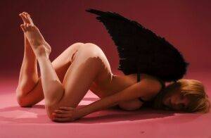 Barely legal girl Hypatia K sports dark angel wings while modeling in the nude on picsofsex.com