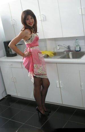 Lusty housewife Dirty Angie wearing sexy black lingerie in the kitchen on picsofsex.com