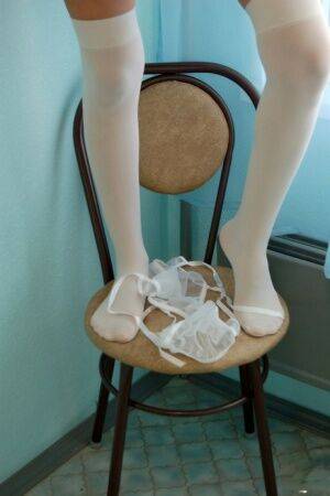 Thin brunette strips to white over the knee stockings on kitchen stool on picsofsex.com