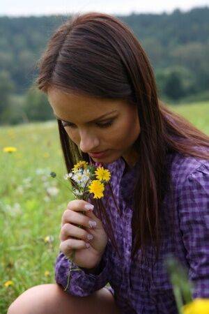 Young girl gets totally naked while picking flowers in a rural field on picsofsex.com