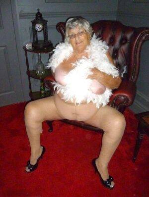 Fat nan Grandma Libby wears a feather boa while baring her saggy tits and butt on picsofsex.com