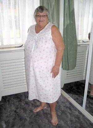 Old woman Grandma Libby grabs her fat roll after getting naked on a bed on picsofsex.com