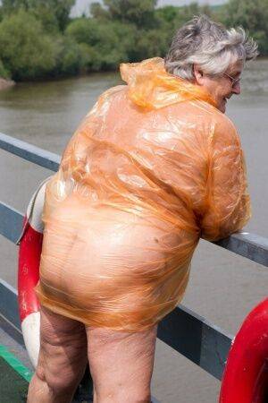 Obese oma Grandma Libby doffs a see-through raincoat to get naked on a bridge on picsofsex.com