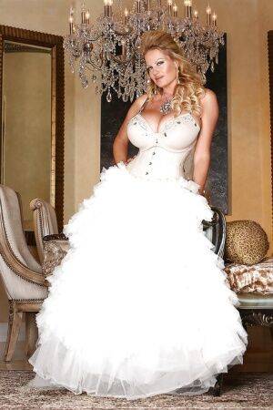 Kelly Madison is posing in a sexy wedding dress and white stockings on picsofsex.com