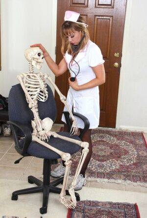 Sexy nurse Christy James peels her white uniform to facesit on a skeleton on picsofsex.com