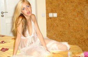 Hot young blonde teen in sheer white lingerie posing with tiny tits beared on picsofsex.com