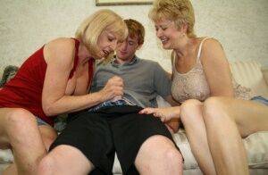 Two blonde grannies share a horny student's hard white dick on the sofa on picsofsex.com