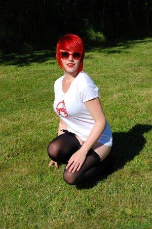 Redheaded amateur Sabrina soaks her white T-shirt out on a lawn in sunglasses on picsofsex.com