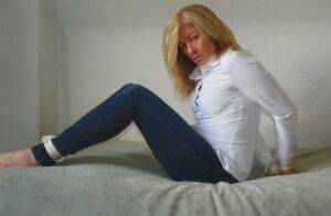 Blonde woman is cleave gagged and hogtied in a white blouse and blue jeans on picsofsex.com