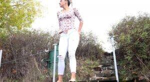 Mature Bianca pulls down her white pants to take a steaming pee outside on picsofsex.com