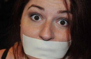 White girl is silenced with medical tape while tied up in her clothing on picsofsex.com