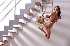 Naked white girl is suspended in midair by ropes with no one else around on picsofsex.com