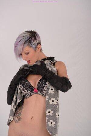 Solo girl with short dyed hair bares her tits and twat in long leather gloves on picsofsex.com