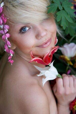 Cute young blonde Iveta poses in the nude while in a garden on picsofsex.com