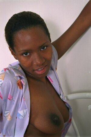 Teen ebony Dazy is lying naked and playing with nice big boobs on picsofsex.com