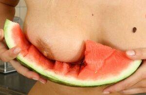 Blonde vixen Flower undressing in the kitchen to eat melon with bare big tits on picsofsex.com