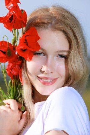 Sweet teen Genevieve Gandi strips naked in a field of blooming flowers on picsofsex.com