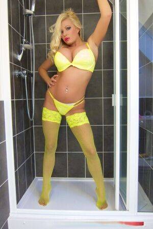 Blond bombshell Michelle Thorne toys her twat in shower wearing yellow hosiery on picsofsex.com