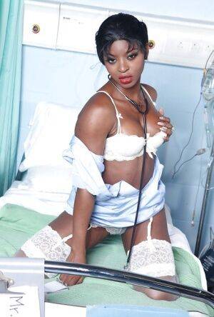 Raunchy ebony nurse with pigtails Jasmine Webb taking off her uniform on picsofsex.com