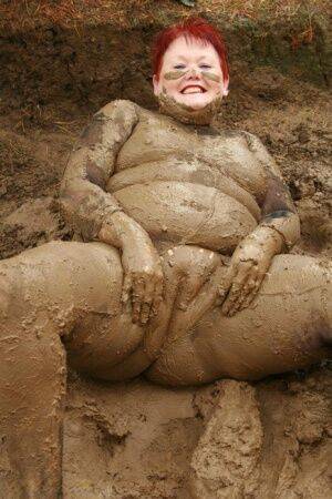 Older redhead Valgasmic Exposed rolls around in a mud pit while totally naked on picsofsex.com