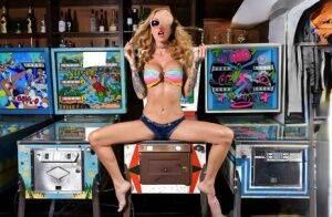 Inked chick Sarah Jessie toys her pussy atop a pinball machine while alone on picsofsex.com